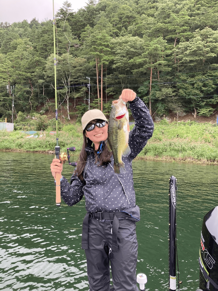 An adult holding up a fish caught from a boat