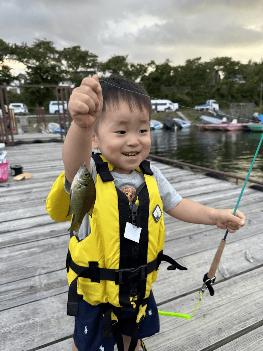 A child showing a fish caught from a jetty